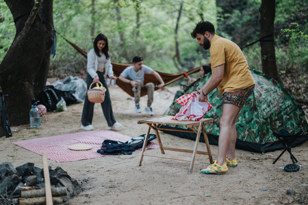 Group of friends enjoying outdoor camping in a forest clearing togetherの写真素材