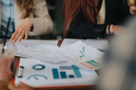 Business associates collaborating over graphs and charts in a professional meetingの写真素材