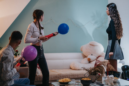 Group of friends preparing a home birthday party with balloons and decorationsの写真素材