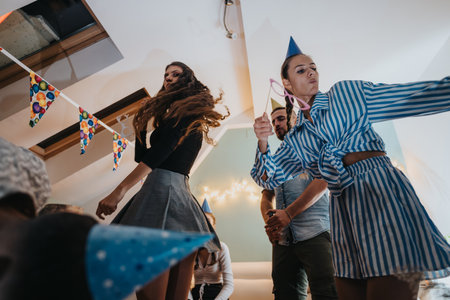 Family enjoying a lively birthday party celebration at home with festive decorations.の写真素材