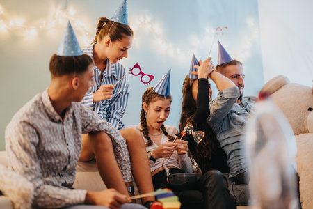 Family celebrating a birthday with party decorations and festive activities at homeの写真素材