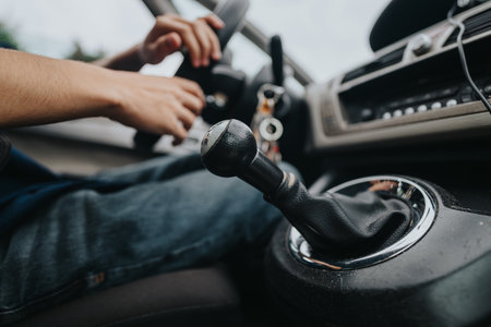 Close-up of manual gear shift inside a car with driver hands