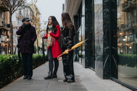 Casual meeting of three women enjoying a winter day in the city streetsの写真素材