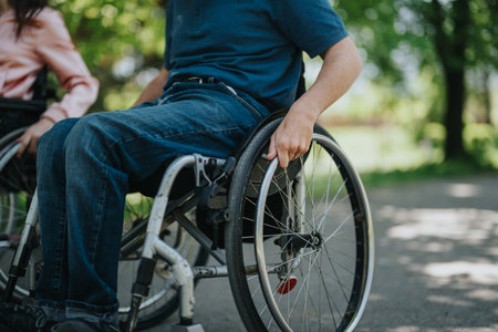 Young individuals in wheelchairs enjoying outdoor time together in a parkの写真素材