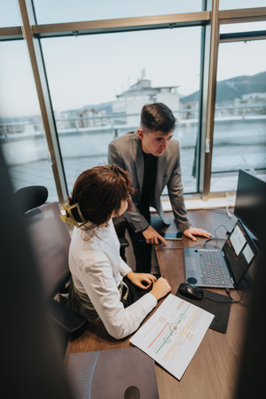 Two professionals collaborating in a modern office environment with a city view