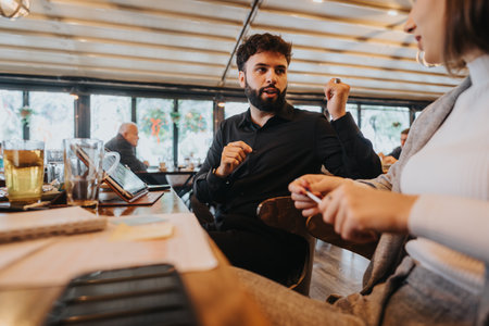 Young professionals discussing ideas during a meeting in a cozy cafe setting