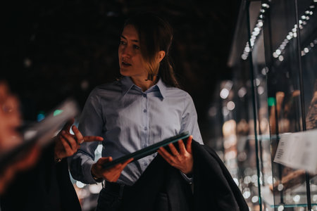 Woman in a museum discussing exhibits with a colleague in a dark ambiance