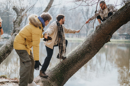 Friends helping each other cross a tree over a lake on an adventure