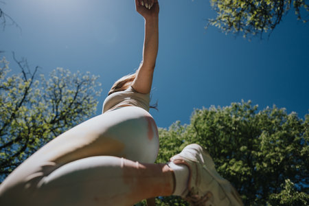 Woman enjoying outdoor activities under a clear sky surrounded by lush greenery