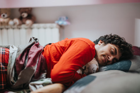 Young man in red sweater sleeping peacefully with stuffed animal