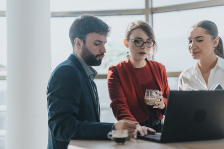 Business team collaborating on laptop in modern office setting