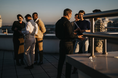 Diverse business people brainstorming on a high tower balcony at sunsetの写真素材