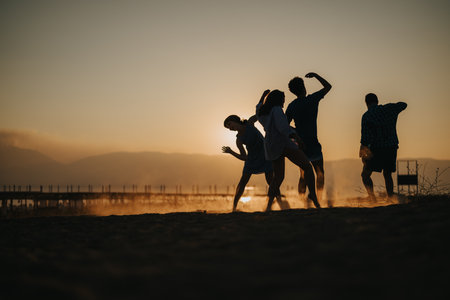 Friends enjoying sunset dance on the beach with a scenic backdrop