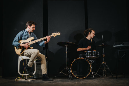 Musicians rehearsing with guitar and drums in a studio setting