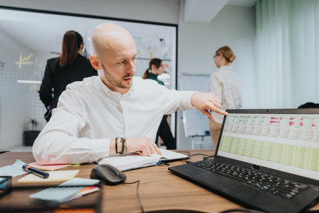 Team collaboration in a modern office environment with team members analyzing data on a laptop