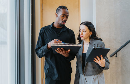 Two business people discussing work and collaborating in an office environmentの写真素材