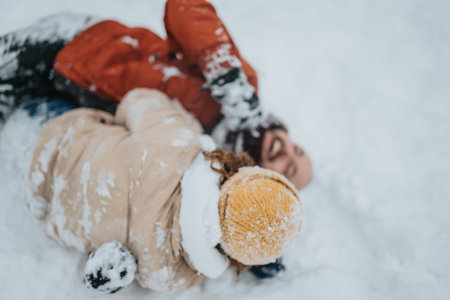 Happy couple enjoying a playful snow day together outdoors in winterの写真素材