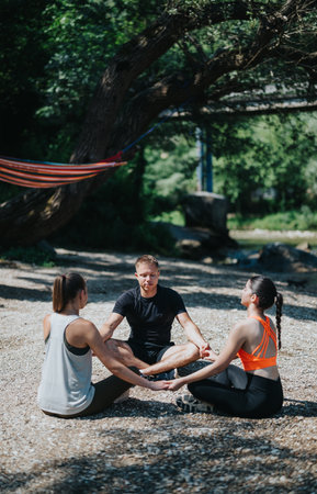 Group yoga session in a tranquil riverside setting on a sunny dayの写真素材
