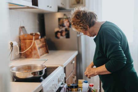 Elderly Woman Cooking in a Cozy Kitchen Settingの写真素材