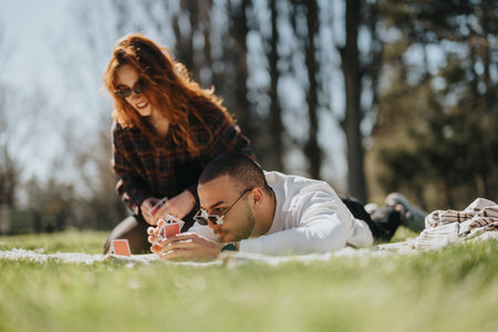 Happy couple enjoying leisure time with a card game in a park