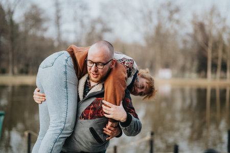 Playful couple enjoying outdoor time together near a calm pondの写真素材