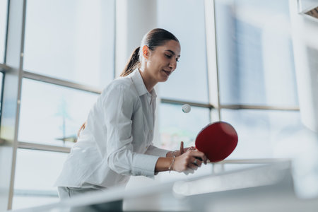 Business employee playing table tennis for team building exerciseの写真素材