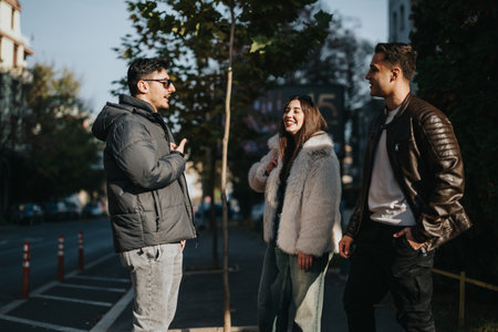 Group of friends enjoying a conversation on a city street in daylightの写真素材