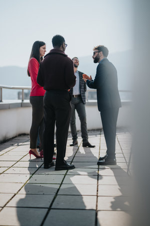 Group of people engaged in an outdoor discussion under natural lightの写真素材