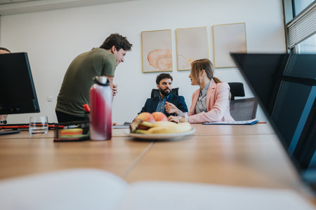 Three colleagues discussing ideas in a modern workplace settingの写真素材