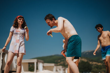 Group of friends enjoying summer by the lake in the sunlightの写真素材