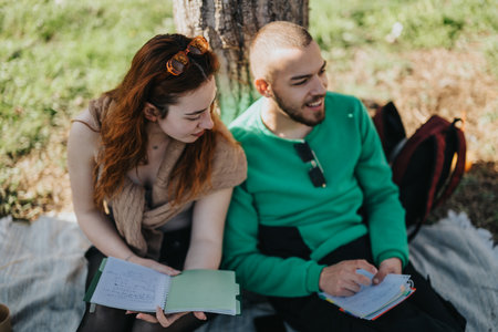Young couple studying together outdoors on a sunny dayの写真素材