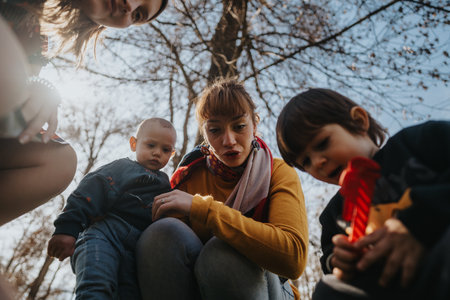 Group of adults and children exploring outdoors during a bright sunny dayの写真素材