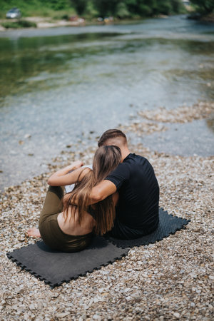 Couple relaxing by a riverside on a sunny day outdoorsの写真素材