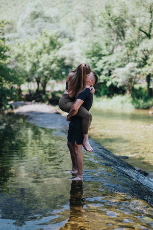 Couple sharing a romantic moment by a serene natural streamの写真素材