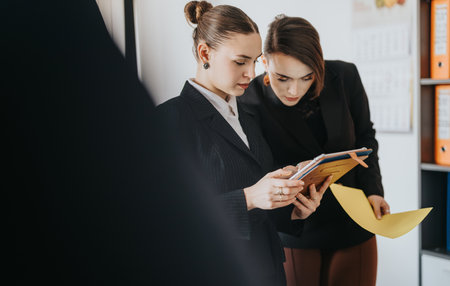 Two professional colleagues collaborating on a project in a modern office settingの写真素材