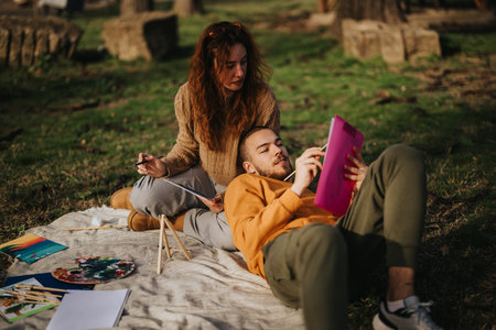 Young couple painting outdoors and enjoying a creative and peaceful momentの写真素材