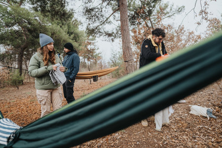 Young friends setting up a campsite in a wooded outdoor areaの写真素材