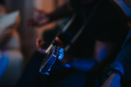 Playing a guitar in intimate and moody lighting atmosphereの写真素材