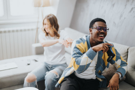 Diverse couple enjoying a playful moment together at homeの写真素材