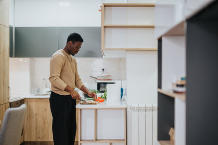 Man preparing a healthy meal in a stylish modern kitchenの写真素材
