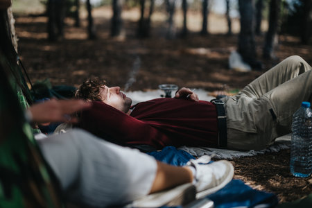 Person relaxing under trees enjoying nature in a serene woodland settingの写真素材
