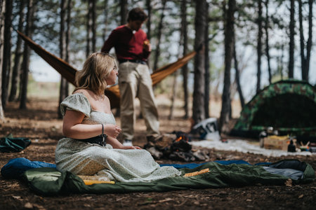 Two people enjoying a relaxing camping experience in a peaceful forest settingの写真素材