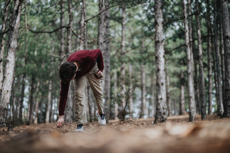 Person exploring a quiet forest on an autumn day, engaged in natureの写真素材