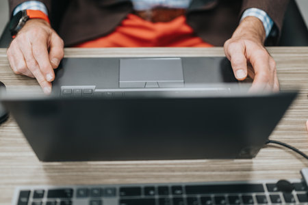 Business professional working on design tablet and laptop in modern office setupの写真素材