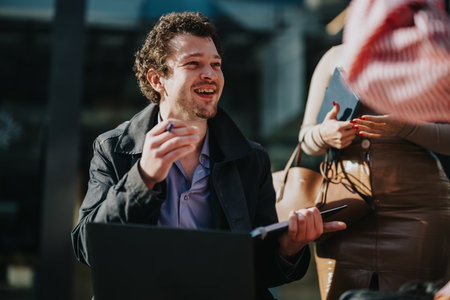 Smiling businessman having a casual meeting outdoors with colleaguesの写真素材