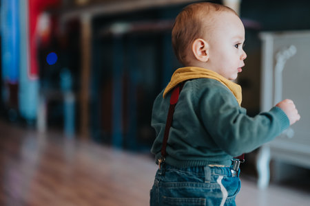 Baby wearing casual clothing walking indoors with a blurred backgroundの写真素材