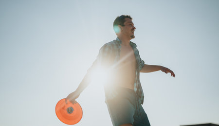 Man Playing With A Frisbee Outdoors On A Bright Sunny Dayの写真素材
