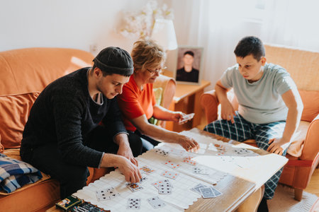 Family gathering playing a card game together in a cozy living room settingの写真素材