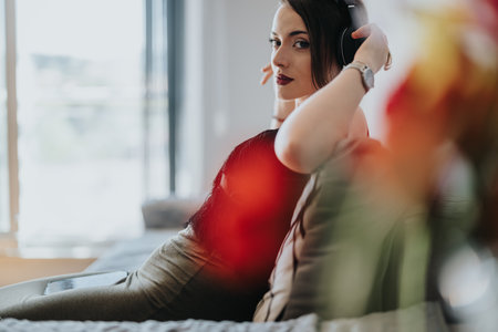 Woman relaxing on sofa listening to music with headphonesの写真素材