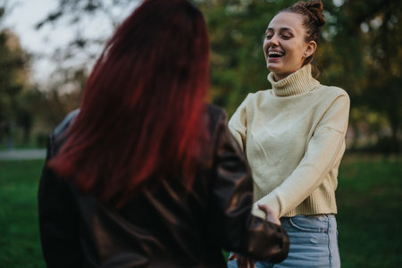 Two women enjoying a cheerful moment in a park settingの写真素材